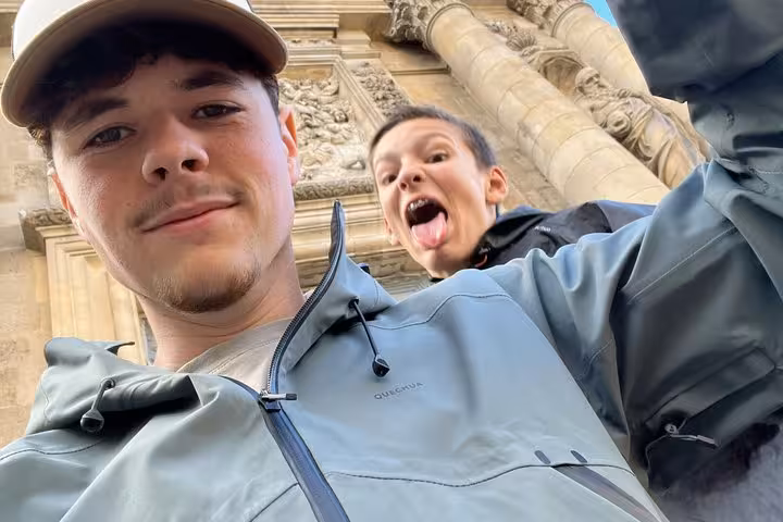 Two young travelers taking a selfie in front of historic Bordeaux Old Town stone architecture
