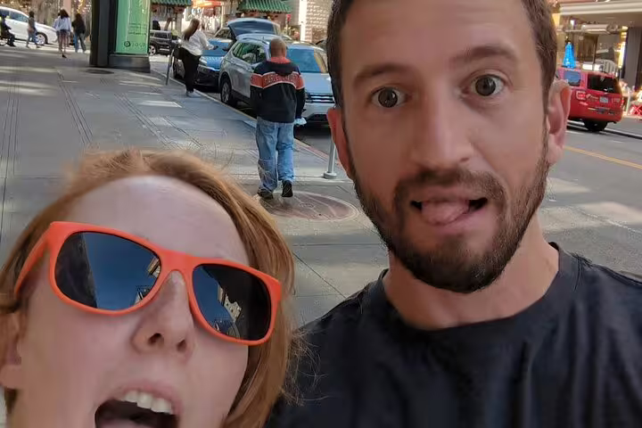 Two excited tourists taking a selfie on a San Francisco street during a self-guided walking tour