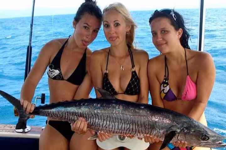 Tourists holding a big wahoo on a boat during a Hurghada fishing tour on the Red Sea, Egypt