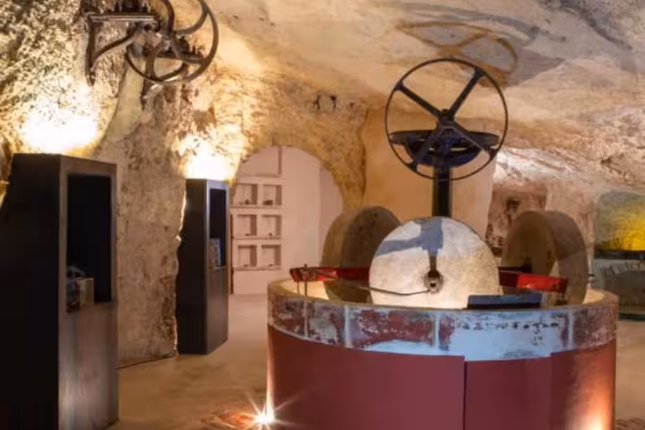 Close-up of traditional milling machinery in a stone-walled underground mill near Alberobello, ideal for tours.