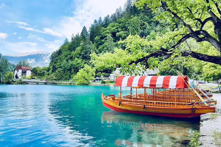 Traditional pletna boat on Lake Bled in summer, scenic stop on Bled Castle tour with relaxing boat ride