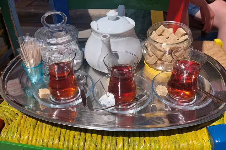 Traditional tea set with three glasses and sugar cubes at Chania's market, offering a taste of local culture.