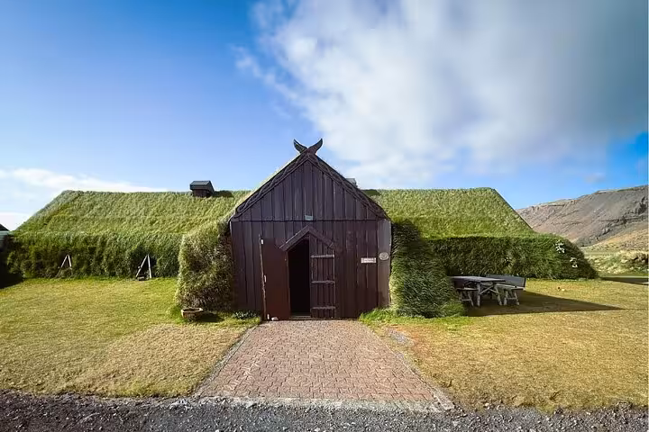 Traditional Icelandic turf house with grass-covered roof and wooden facade in the Westfjords region