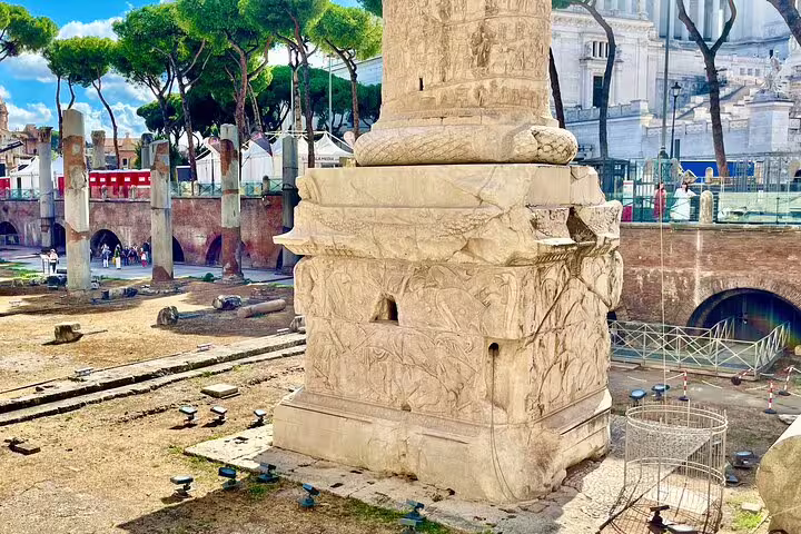 Close-up of Trajan’s Column base with detailed Roman carvings in the archaeological ruins by the Roman Forum in Rome