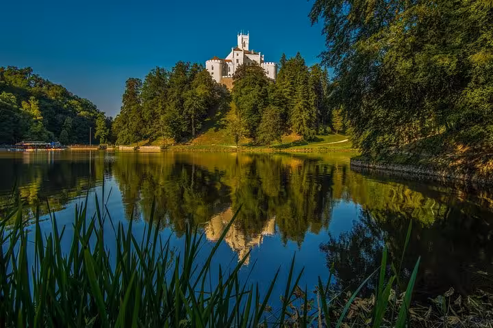 Trakoscan Castle above the forested lake with clear reflections, popular viewpoint on a private tour from Zagreb
