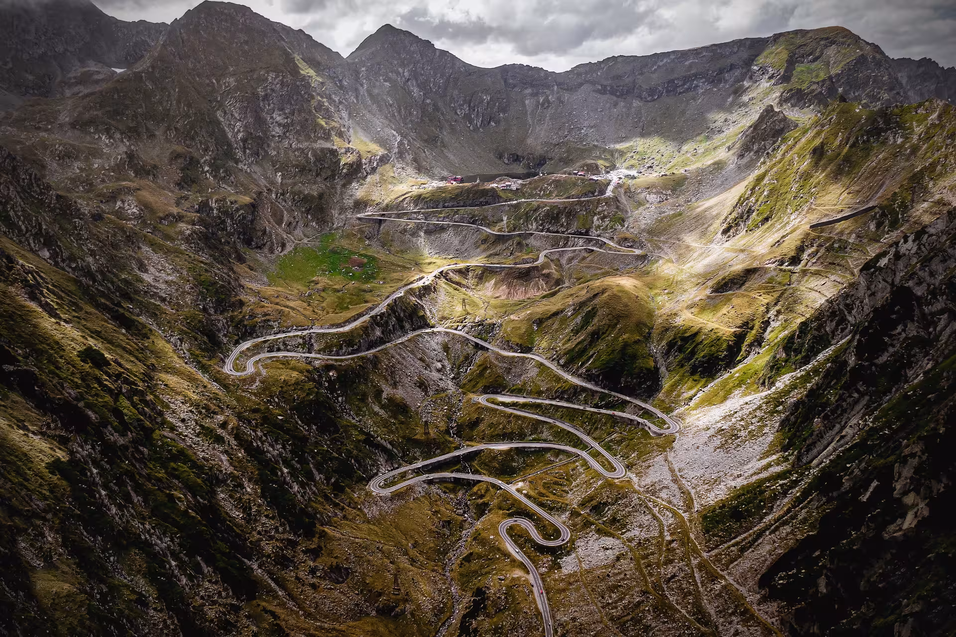 Aerial view of Transfăgărășan winding mountain road switchbacks through Carpathian Mountains, Transylvania, Romania