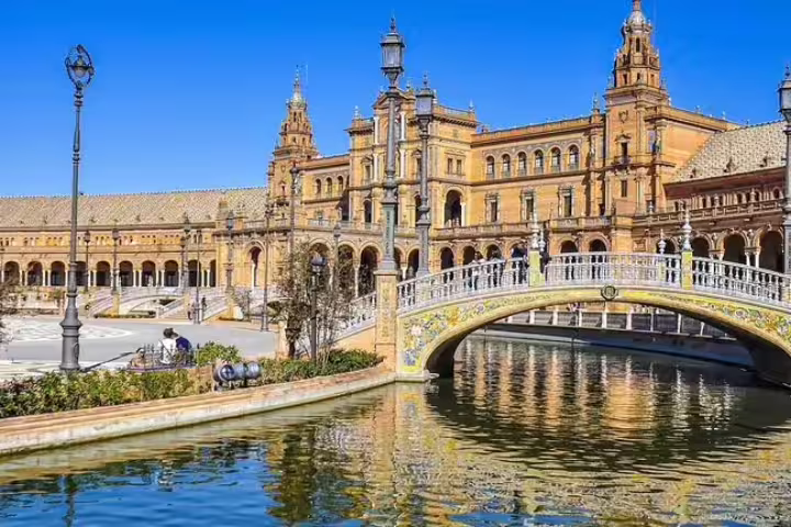 Scenic view of Plaza de España in Seville on a sunny day, showcasing its iconic architecture and picturesque canal.