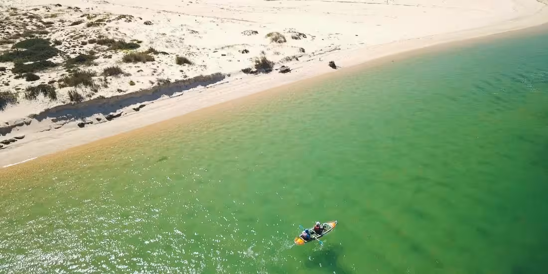 Aerial view of a transparent kayak near a sandy beach, perfect for a 4-hour clear kayak rental on calm waters