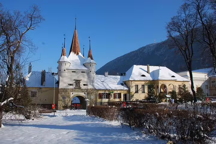 Snow-covered medieval castle gate with pointed towers in Transylvania, Romania in winter