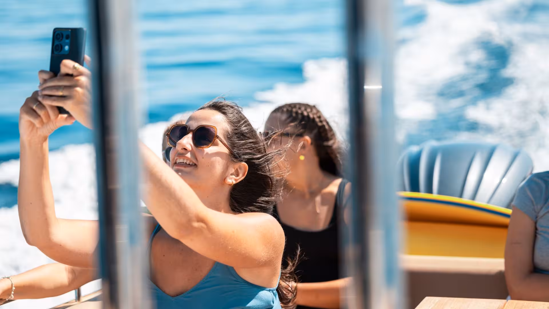 Woman taking a selfie on a dinghy tour from Trapani to Levanzo, enjoying the sea breeze and sunshine.