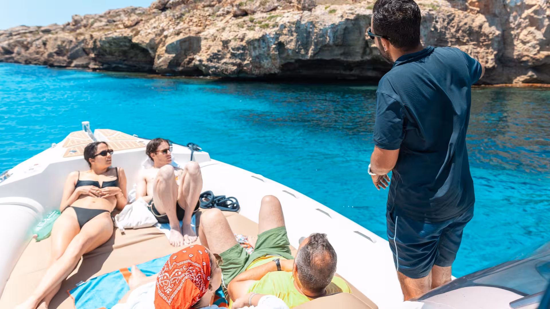 Group enjoying a sun-soaked dinghy tour near rocky shores on Favignana and Levanzo with clear turquoise waters.