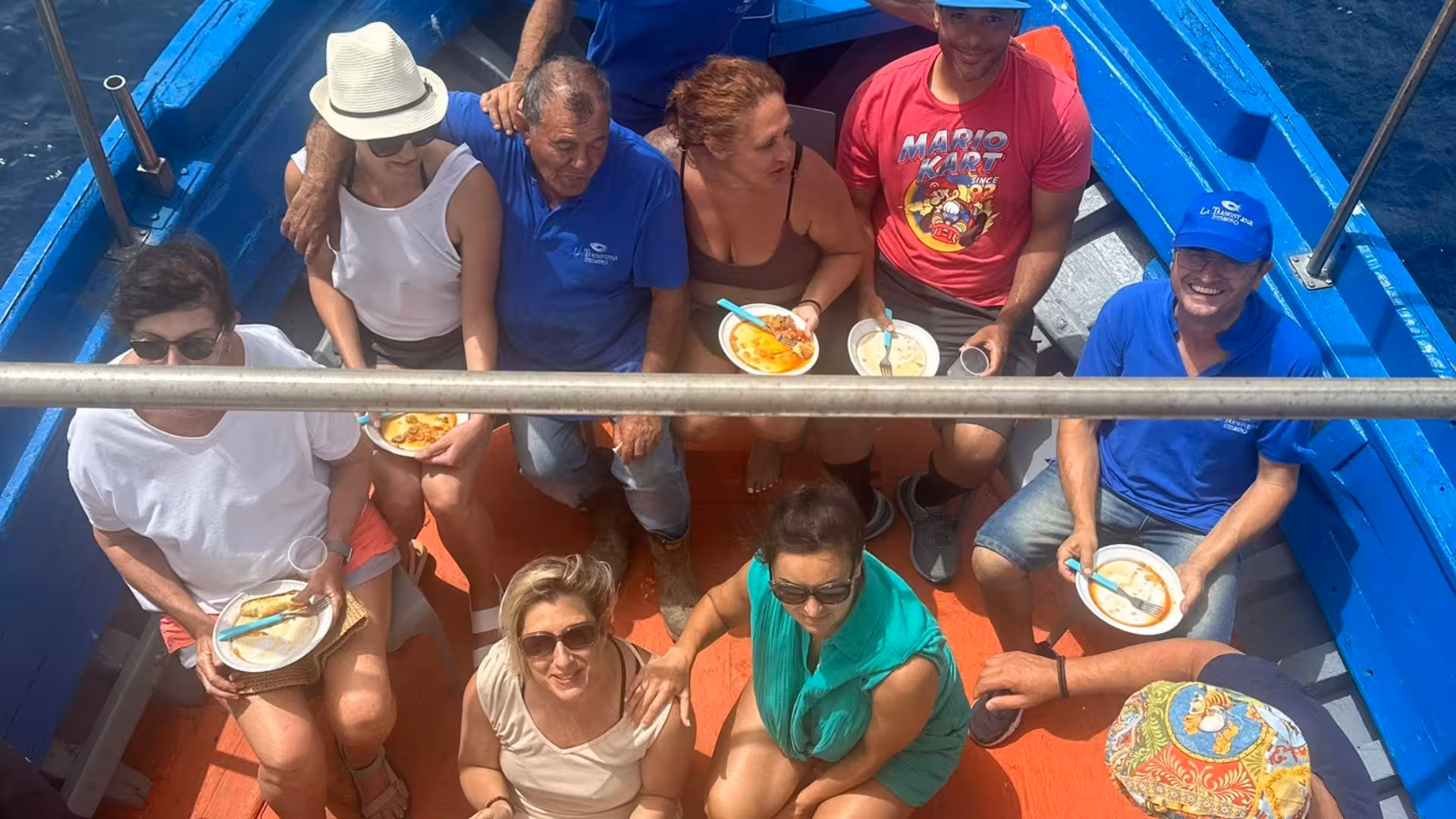 Group enjoying a meal aboard a fishing boat during the Egadi Islands tour from Trapani.