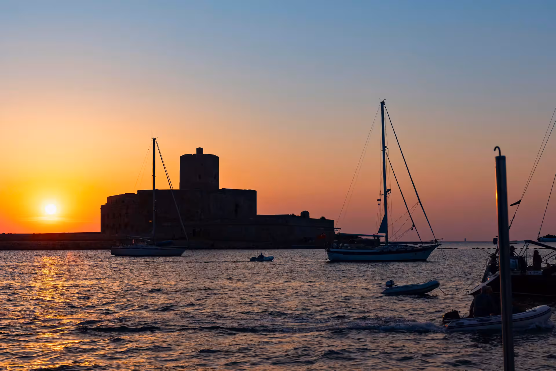 Sunset over Trapani harbor with sailboats, starting point for Egadi Islands dinghy tour to Favignana and Levanzo