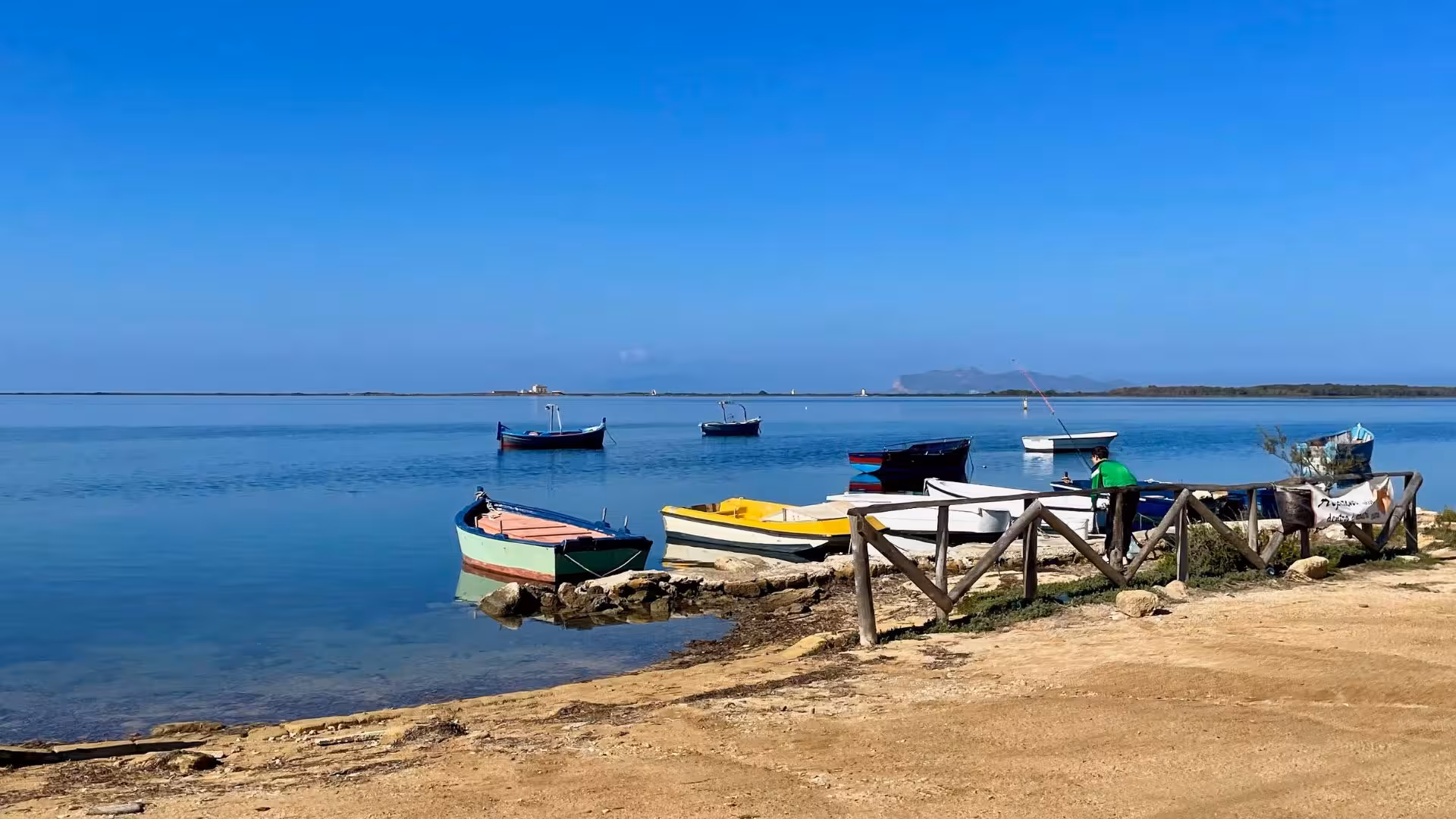Colorful boats float on the tranquil waters near Marsala, perfect for a peaceful stop on an ebike tour from Trapani.