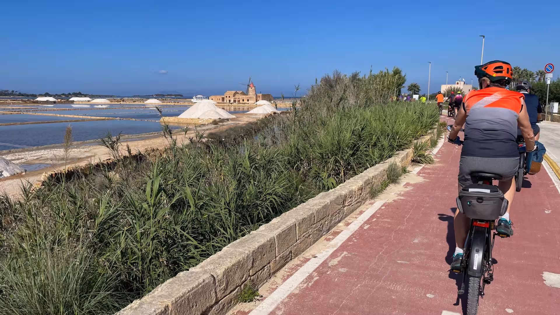Ebike riders explore the picturesque salt flats and windmills on the route from Trapani to Marsala.