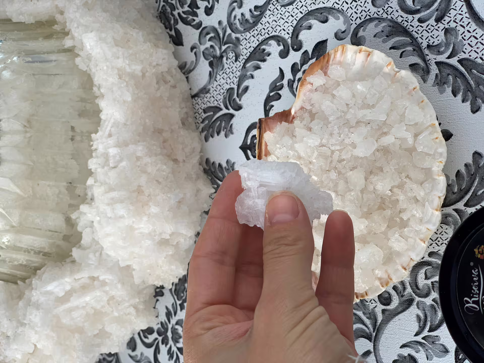 Hand holding coarse sea salt crystals from the Trapani salt pans, sampled on a private tour from Palermo