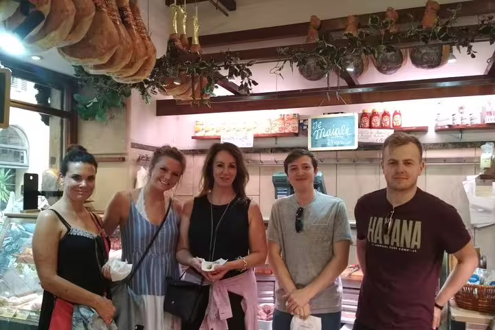 Tourists enjoying authentic Roman street food inside a traditional Trastevere salumeria on a guided walking food tour.