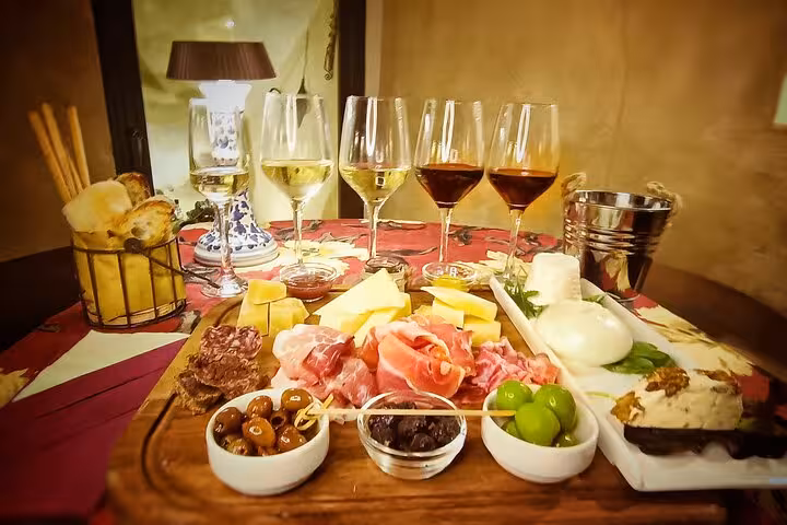 Gourmet Trastevere wine tasting table with Italian cold cuts, cheeses, olives and breadsticks paired with white and red wines in Rome