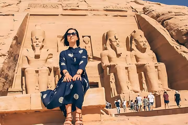 Traveler posing at Abu Simbel temples, Ramses II statues, on Luxor and Abu Simbel 2-day private tour from Hurghada