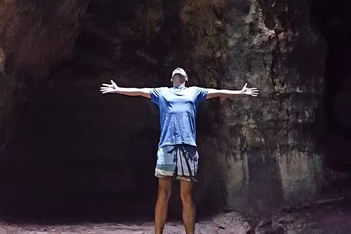 Traveler posing inside Amazon rainforest cave on Presidente Figueiredo waterfalls day tour from Manaus