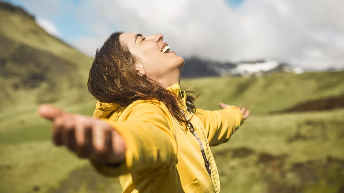 A closeup shot of a person with their arms outstretched and head tilted back