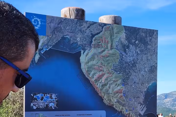 Traveler reading Calanques National Park map near Cassis on full-day Aix en Provence, Cassis and Marseille tour