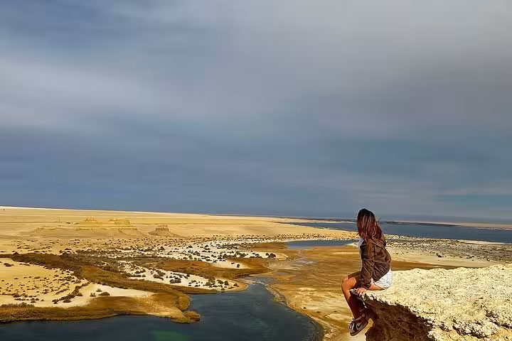 Traveler overlooking Fayoum Magic Lake from a desert cliff on Cairo to Fayoum Oasis dunes adventure tour