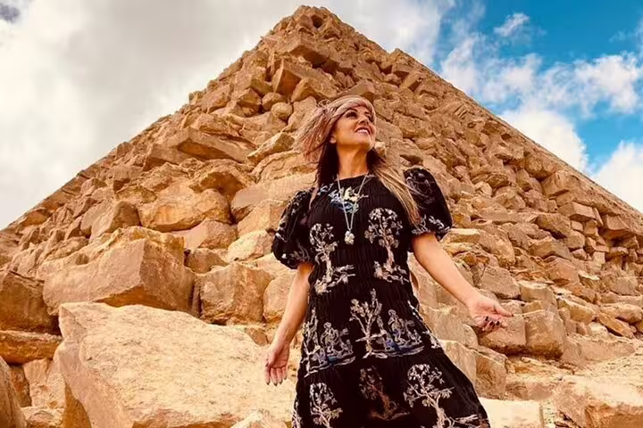Traveler posing by Giza Pyramid stones during private Cairo tour combining NEMC, Egyptian Museum and Giza
