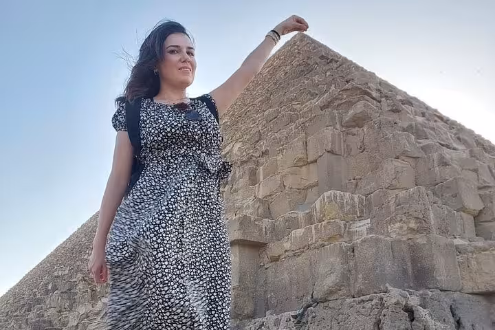 Traveler posing beside the Great Pyramid of Giza on Cairo tour combining ATV ride, felucca sailing and market visit