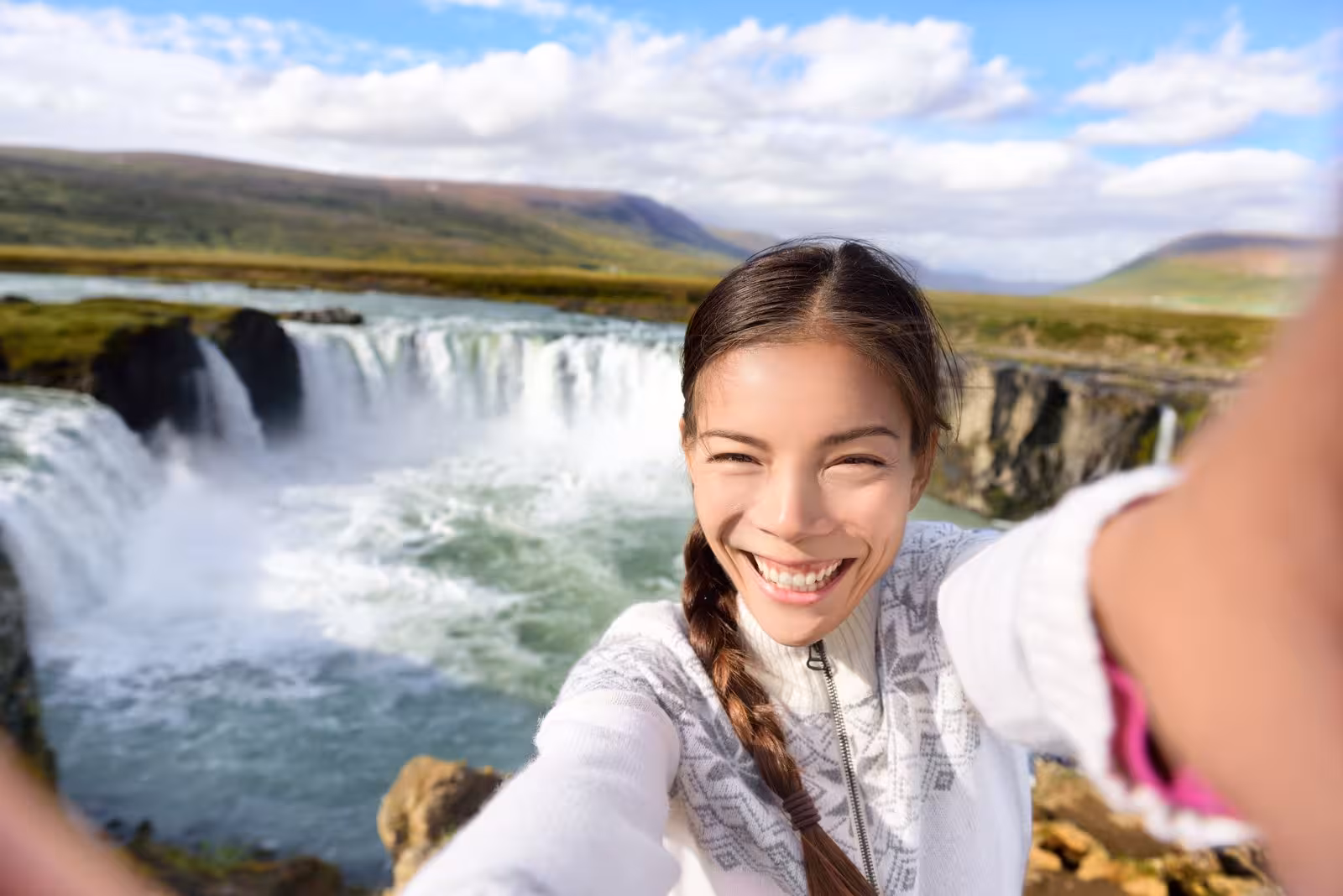 Traveler selfie at Godafoss waterfall, North Iceland, during a 7-day small group journey around Iceland