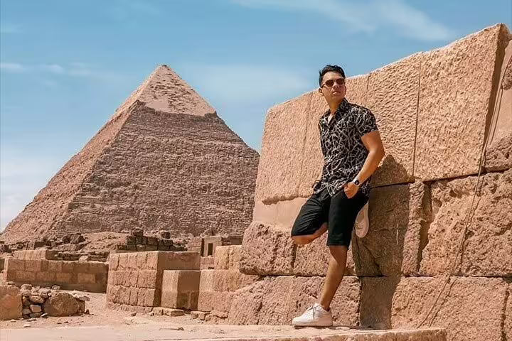 Traveler posing by the Great Pyramid of Giza on Cairo day trip from Luxor by flight, 2-day tour