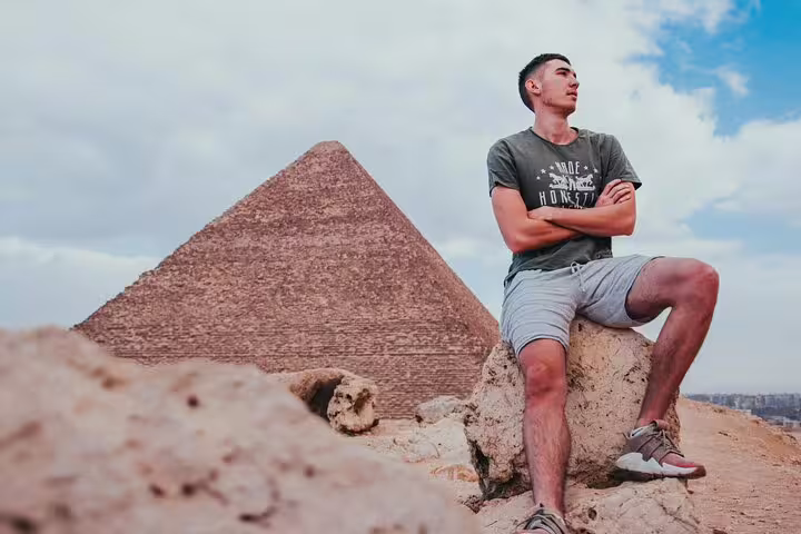 Traveler posing near the Great Pyramid of Giza on Cairo excursion, included in 2-day Marsa Alam to Cairo & Luxor by flight