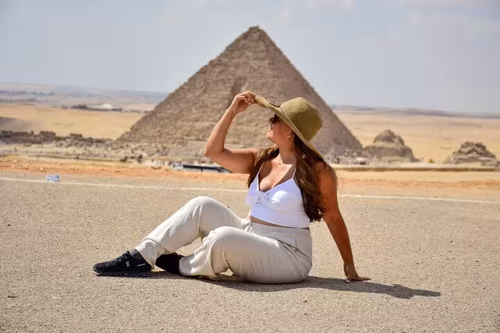 Traveler relaxing near the Great Pyramid of Giza on a Cairo day tour with optional Tutankhamun mask visit
