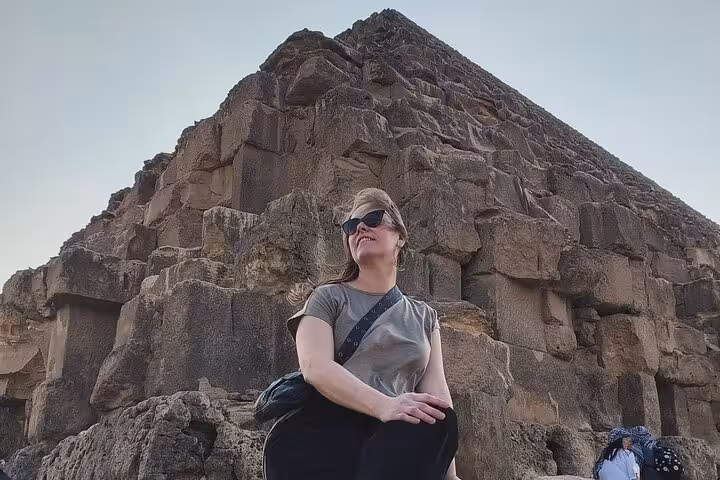 Traveler posing by the Great Pyramid of Giza stones, highlight stop on private Giza Pyramids tour Cairo