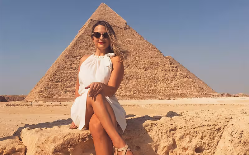 Traveler posing by the Great Pyramid of Giza, included in private Grand Egyptian Museum and pyramids tour Cairo