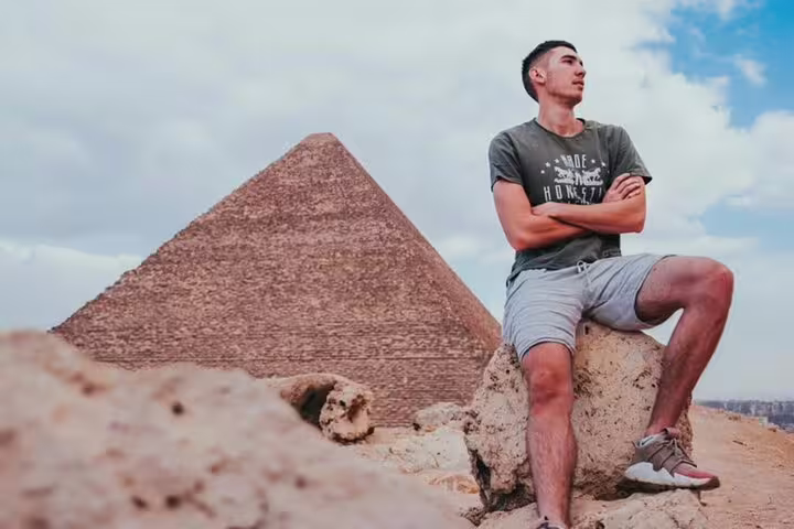 Traveler posing by the Great Pyramid of Giza on a Cairo day tour from Alexandria Port shore excursion