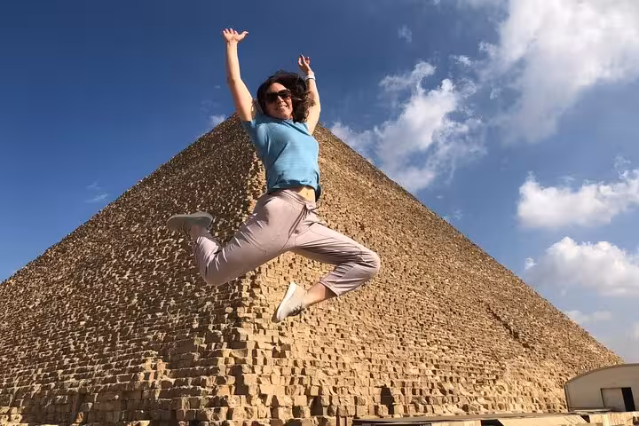 Traveler jumping in front of Great Pyramid of Giza on all-inclusive tour with pyramid entry, Sphinx and camel ride