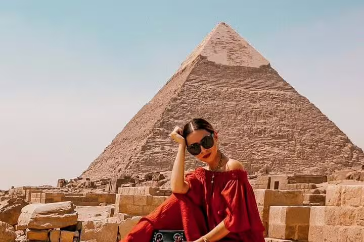 Traveler posing at the Great Pyramid of Giza on a private guided tour with Grand Egyptian Museum visit