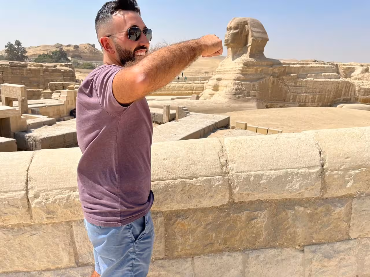 Traveler poses by the Great Sphinx of Giza, Cairo, on Giza Pyramids camel ride and lunch tour
