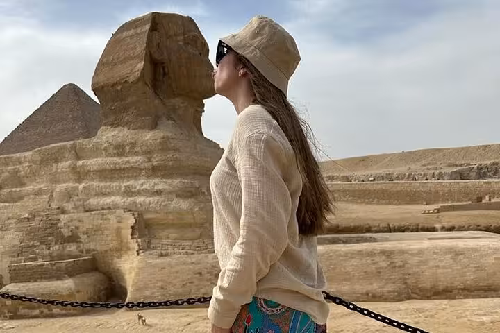 Traveler posing by the Great Sphinx with Giza Pyramid behind on a 4-day private Cairo tour sightseeing