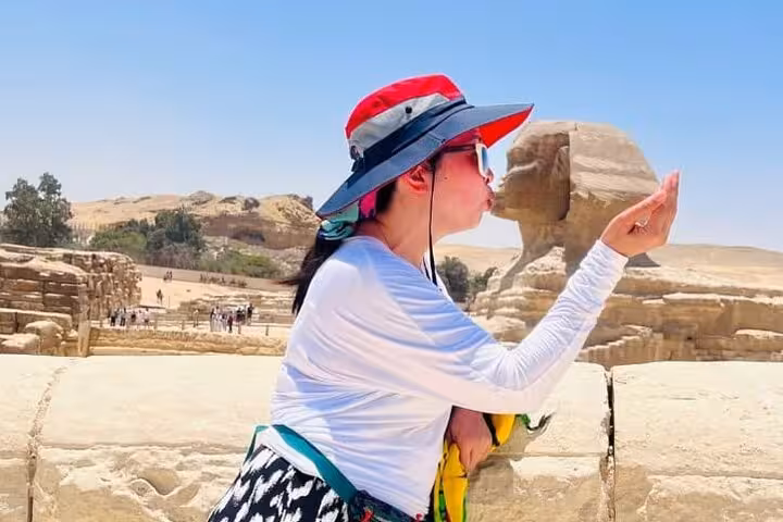 Traveler posing with the Great Sphinx at Giza on full-day all-inclusive pyramids, mummies museum and bazaar tour