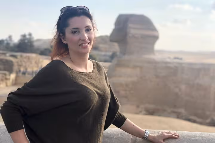 Traveler posing by the Great Sphinx viewpoint on an all-inclusive Giza tour with pyramid entry and camel ride