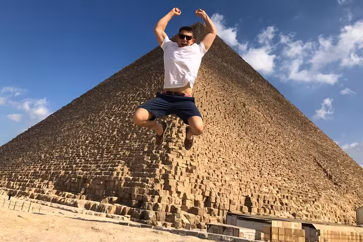 Traveler jumping in front of the Great Pyramid of Giza on a private guided tour with lunch and camel ride