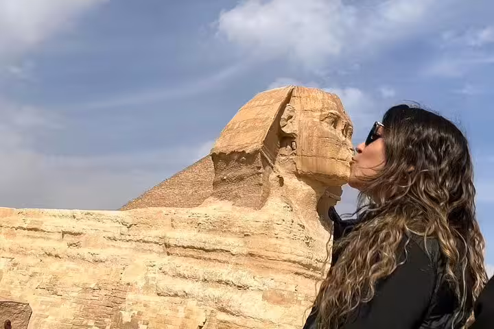 Traveler kissing the Great Sphinx of Giza on a private full-day Cairo tour with Pyramids and guide