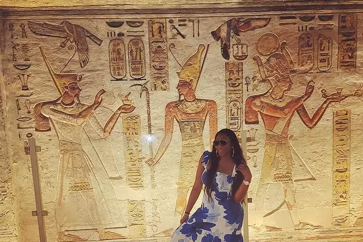 Traveler posing by ancient Egyptian wall carvings in Luxor temple on VIP 2-day highlights tour from Cairo