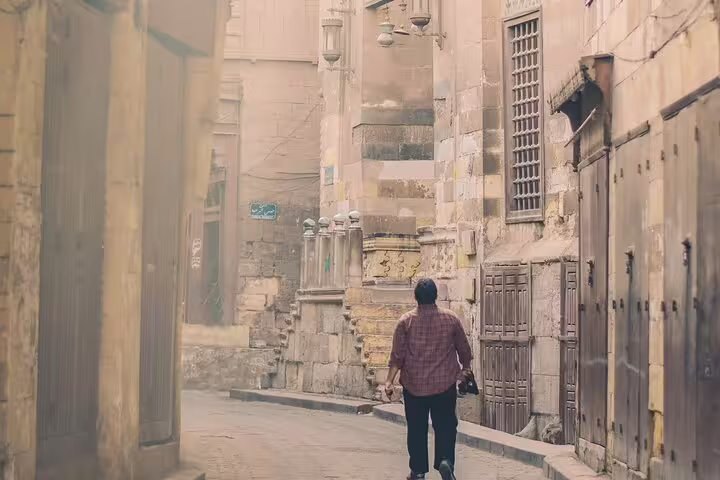 Traveler walking a quiet Old Cairo alley near historic mosques on a guided Islamic Cairo walking tour