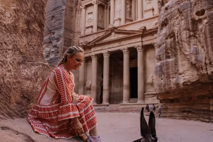 Traveler tying sandals at Petra Treasury in Jordan, highlight of 13-day Egypt Jordan Jerusalem tour