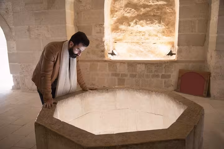 Traveler viewing ancient cistern at Qaitbay Citadel, Alexandria highlights on Cairo full day tour