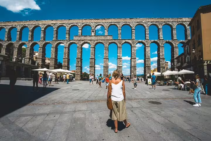 Traveler in front of the Roman Aqueduct on a private Segovia minivan tour from Madrid, iconic UNESCO site