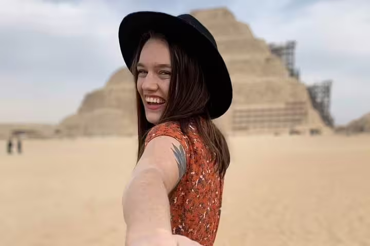 Smiling traveler at Saqqara Step Pyramid on Cairo luxury tour, exploring Memphis and Dahshur pyramids